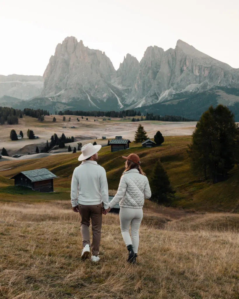 Couple walking through the meadows of Alpe di Siusi in the Dolomites